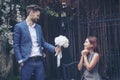 Caucasian handsome man giving flowers to asian girlfriend asking for proposing to marry him at green park. Couple lover on Royalty Free Stock Photo