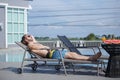 Caucasian handsome man wearing sunglasses lying at near swimming pool, weekend relax luxury travel poolside. Summer vacation Royalty Free Stock Photo