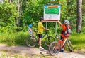 Caucasian happy family with bicycles is near map in the park.