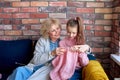 Caucasian multi-generation family knitting. Senior woman and child girl