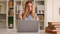 Caucasian happy female student girl at home library studying online with books laptop distant education writing homework Royalty Free Stock Photo