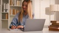 Caucasian happy female student girl at home library studying online with books laptop distant education writing homework Royalty Free Stock Photo