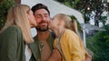 Caucasian happy loving family talking outdoors dad touching nose of little daughter child girl and mother wife kissing Royalty Free Stock Photo