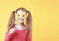 Caucasian happy smiling child girl in yellow glasses on empty space yellow background