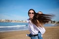 Caucasian happy young mother smiling looking at the camera while giving piggyback ride to her lovely daughter at beach. Royalty Free Stock Photo