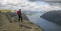 Caucasian hiker posing on ridge of a mountain overlooking the Lysefjord, Norway.