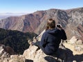 Caucasian hiker woman taking photos at the top of the mountain