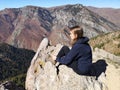 Caucasian hiker woman tying her boots laces at the top of the mountain