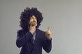 Caucasian hipster man in funny curly afro hair wig thinking and brainstorming