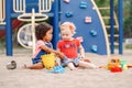 Caucasian and hispanic latin babies children sitting in sandbox playing Royalty Free Stock Photo