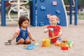 Caucasian and hispanic latin babies children sitting in sandbox playing Royalty Free Stock Photo