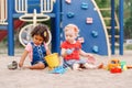 Caucasian and hispanic latin babies children sitting in sandbox playing Royalty Free Stock Photo