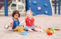 Caucasian and hispanic latin babies children sitting in sandbox playing with plastic colorful toys Royalty Free Stock Photo