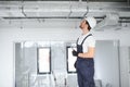 Caucasian HVAC Technician Worker in His 40s Testing Newly Installed Warehouse Ventilation System. Commercial Heating Royalty Free Stock Photo