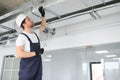 Caucasian HVAC Technician Worker in His 40s Testing Newly Installed Warehouse Ventilation System. Commercial Heating Royalty Free Stock Photo