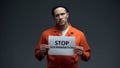 Caucasian imprisoned man holding Stop discrimination sign, racial prejudice