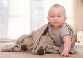 Caucasian infant sitting on floor leaning on one hand