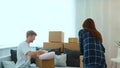 Caucasian joyful man and woman just moved in a new apartment packing their stuff and clothes. Cardboard boxes. Excited Royalty Free Stock Photo