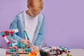 Caucasian kid boy try to assemble complex construction of robotics Royalty Free Stock Photo
