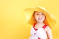 Caucasian child girl in hat on yellow empty space background,summer holiday,vocation