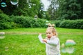 Caucasian kid happy running after soap bubbles in the park Royalty Free Stock Photo