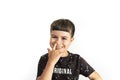 Caucasian kid making a finger-in-the-nose gesture on white background