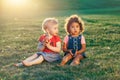 Caucasian and latin hispanic girls children sitting together sharing apple.