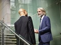 Caucasian and latino business men having a conversation while walking on stairs in modern office building Royalty Free Stock Photo