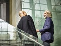 Caucasian and latino business men having a conversation while walking on stairs in modern office building Royalty Free Stock Photo