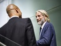 Caucasian and latino business men having a conversation while walking on stairs in modern office building Royalty Free Stock Photo