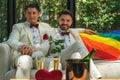 LGBTQ gay couple sitting in living room together in wedding ceremony Royalty Free Stock Photo