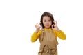 Little child girl in beige chef's apron, gesturing with OK sign, expressing agreement and apreciation on white Royalty Free Stock Photo