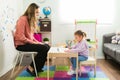 Caucasian little girl coloring and drawing with a female teacher Royalty Free Stock Photo