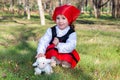 Caucasian little girl dressed as a shepherdess with a stuffed sheep.