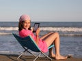 Caucasian Little girl with ebook on the beach