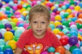 Caucasian little girl of five years old looking at camera among multicolor balls in play center Royalty Free Stock Photo