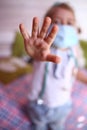 Caucasian little girl in a medical mask at home in her room. Quarantine protection against coronavirus. Home insulat Royalty Free Stock Photo