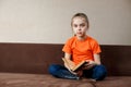 Caucasian Little Girl Sitting On The Sofa Reading a Book At Home Royalty Free Stock Photo