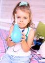 Caucasian little girl with stethoscope at home playing doctor with big blue enema to treat a bear. Little therapist. Coronavirus Royalty Free Stock Photo