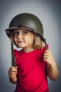 Caucasian little girl wearing a military helmet