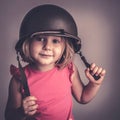 Caucasian little girl wearing a military helmet
