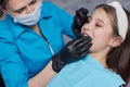 caucasian little kid girl invisible aligner and pointing to her perfect straight teeth. Dental healthcare and confidence