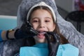 caucasian little kid girl invisible aligner and pointing to her perfect straight teeth. Dental healthcare and confidence