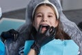 caucasian little kid girl invisible aligner and pointing to her perfect straight teeth. Dental healthcare and confidence