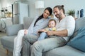 Caucasian loving family watch movie together in living room at home. New marriage couple man and woman sit with young baby boy on Royalty Free Stock Photo