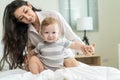 Caucasian loving mom play with cute baby boy child on bed in bedroom. Happy family, attractive beautiful caring young mother Royalty Free Stock Photo