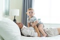 Caucasian loving mom play with cute baby boy child on bed in bedroom. Happy family, attractive beautiful caring young mother Royalty Free Stock Photo