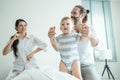 Caucasian loving parents play with baby boy child on bed in bedroom. Happy family, attractive beautiful young couple dad and mom Royalty Free Stock Photo