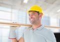 Caucasian male architect carrying a wooden plank against against office window in background