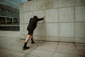 Caucasian male athlete stretching against wall after long run in city